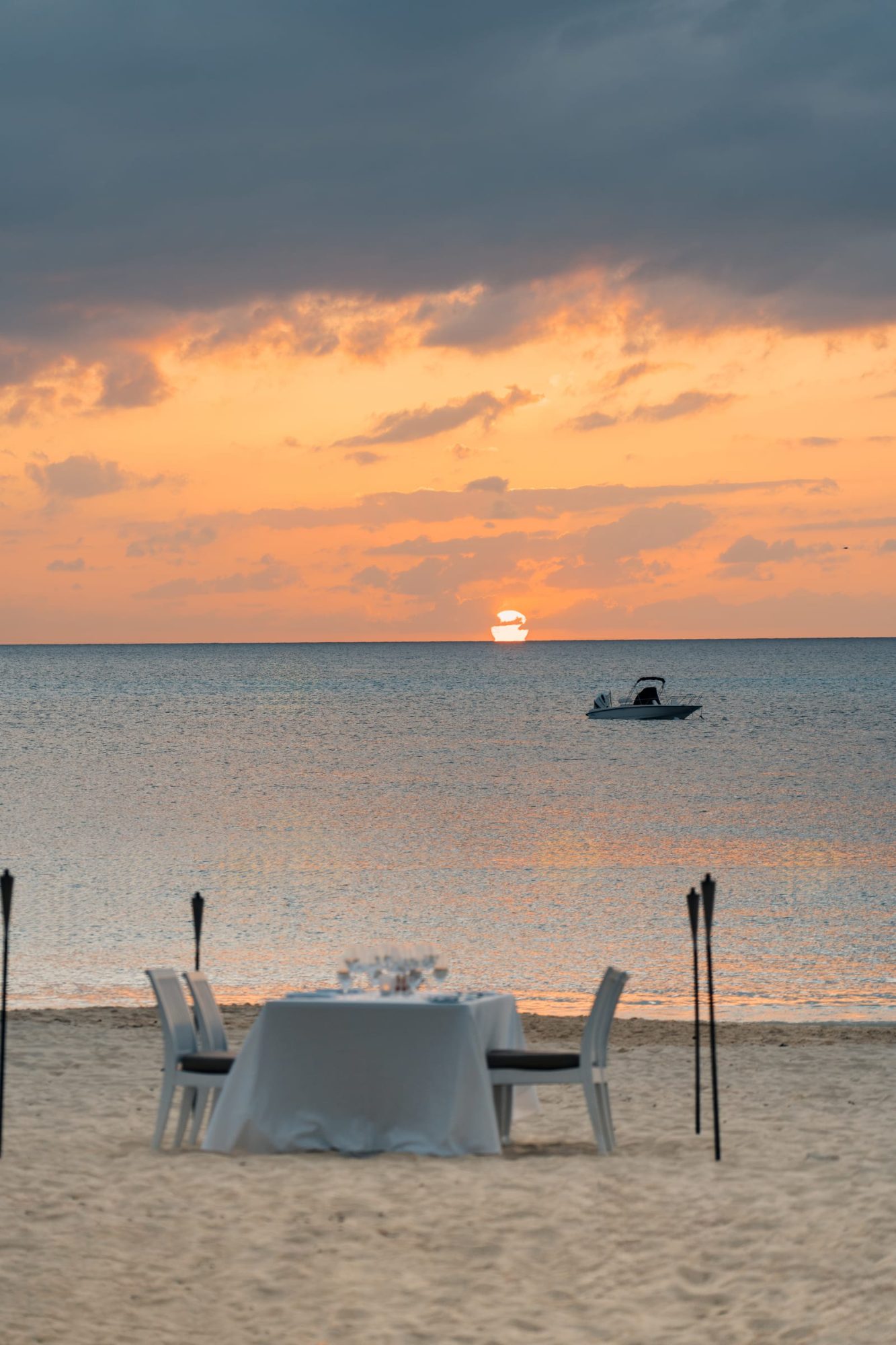 A private table set on the sand at sunset for dinner at the Westin’s Beach House