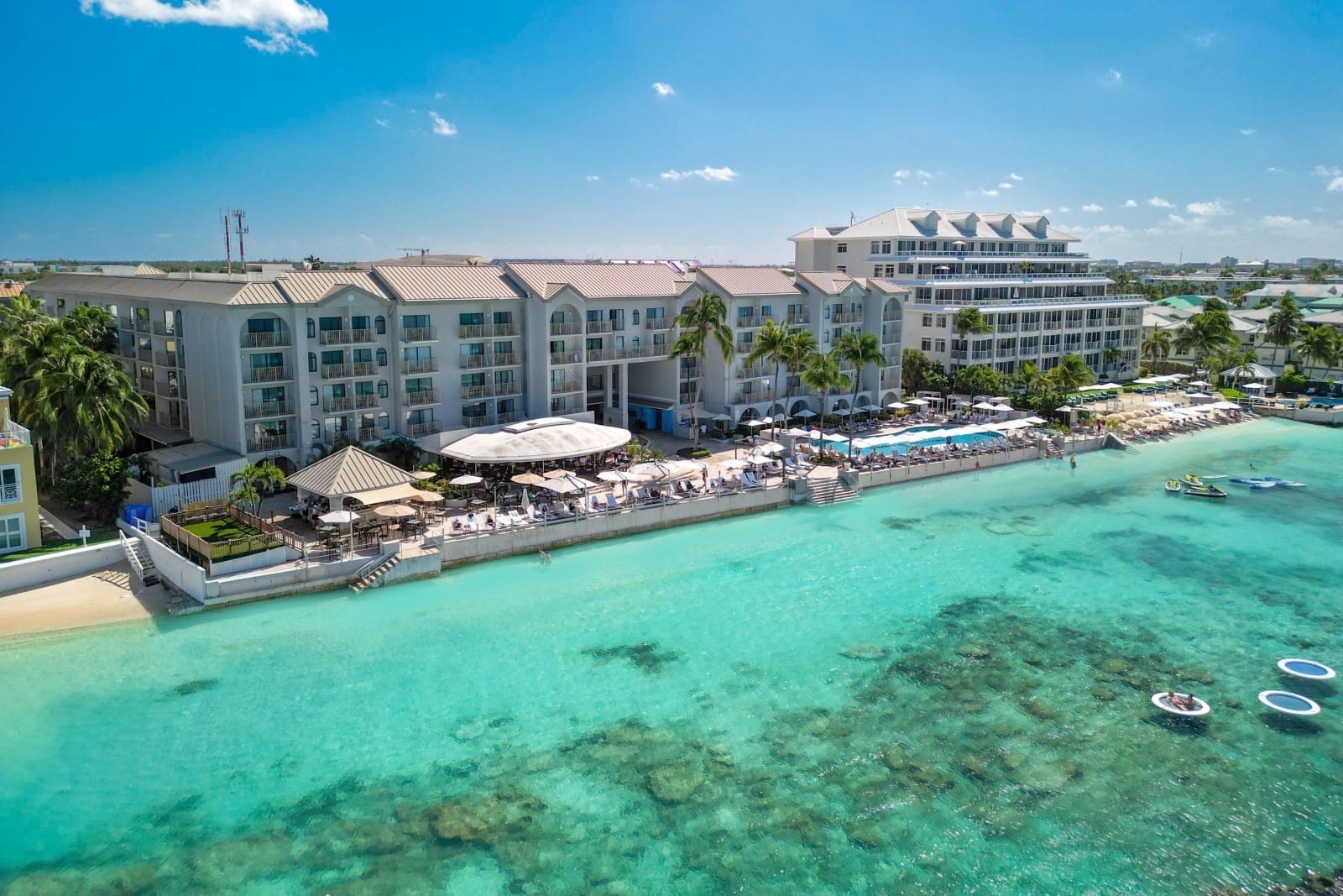 Aerial view of the resort coast along Seven Mile Beach over clear turquoise water
