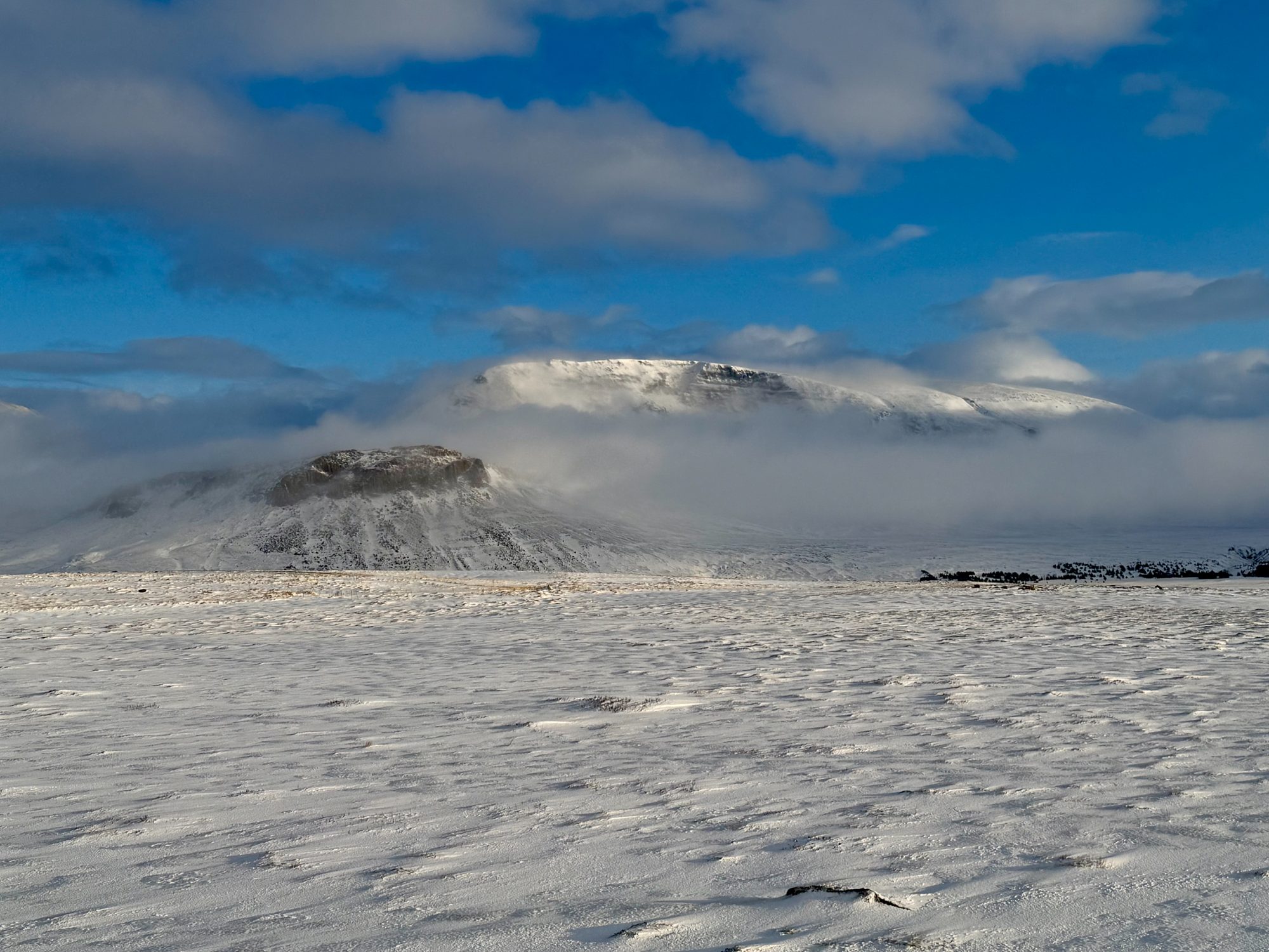 Snow-dusted Icelandic mountains under a bright winter sky