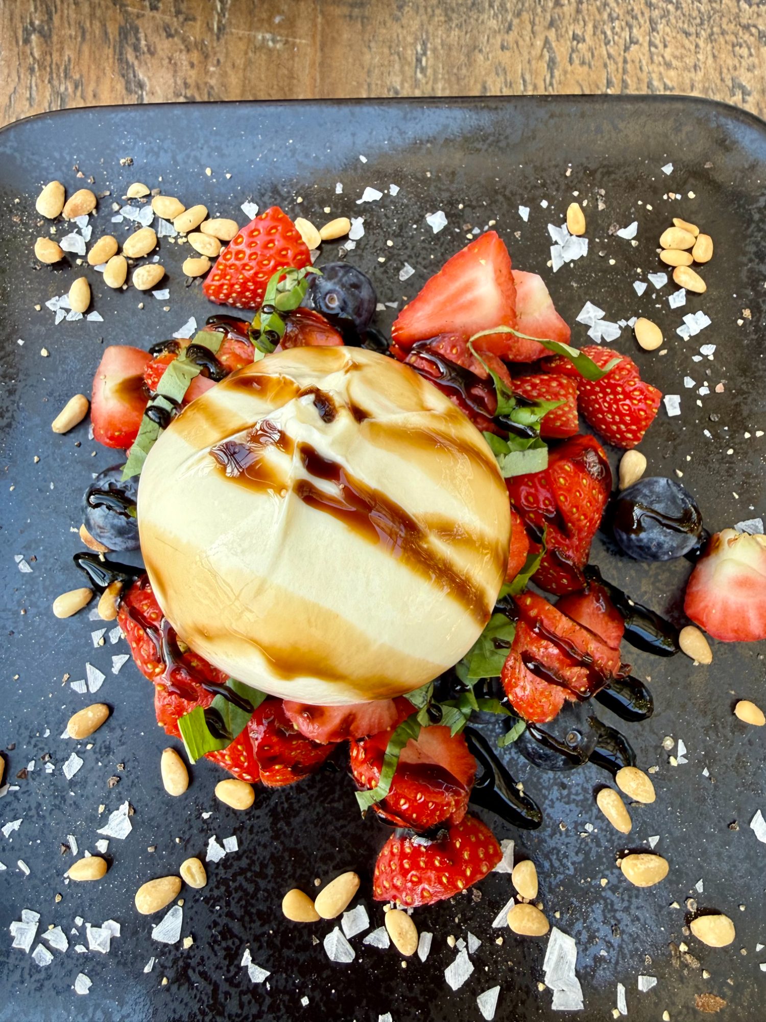 A fresh burrata with strawberries, basil, pine nuts, and balsamic at Friðheimar
