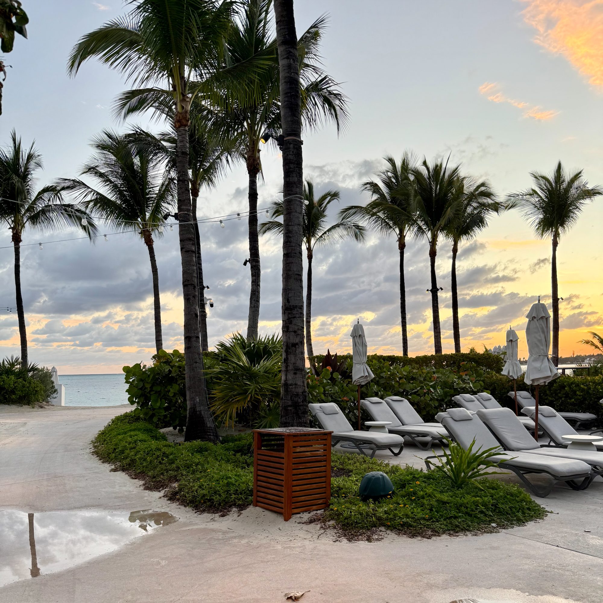 Palms and loungers along the beach at Baha Mar as the sun sets