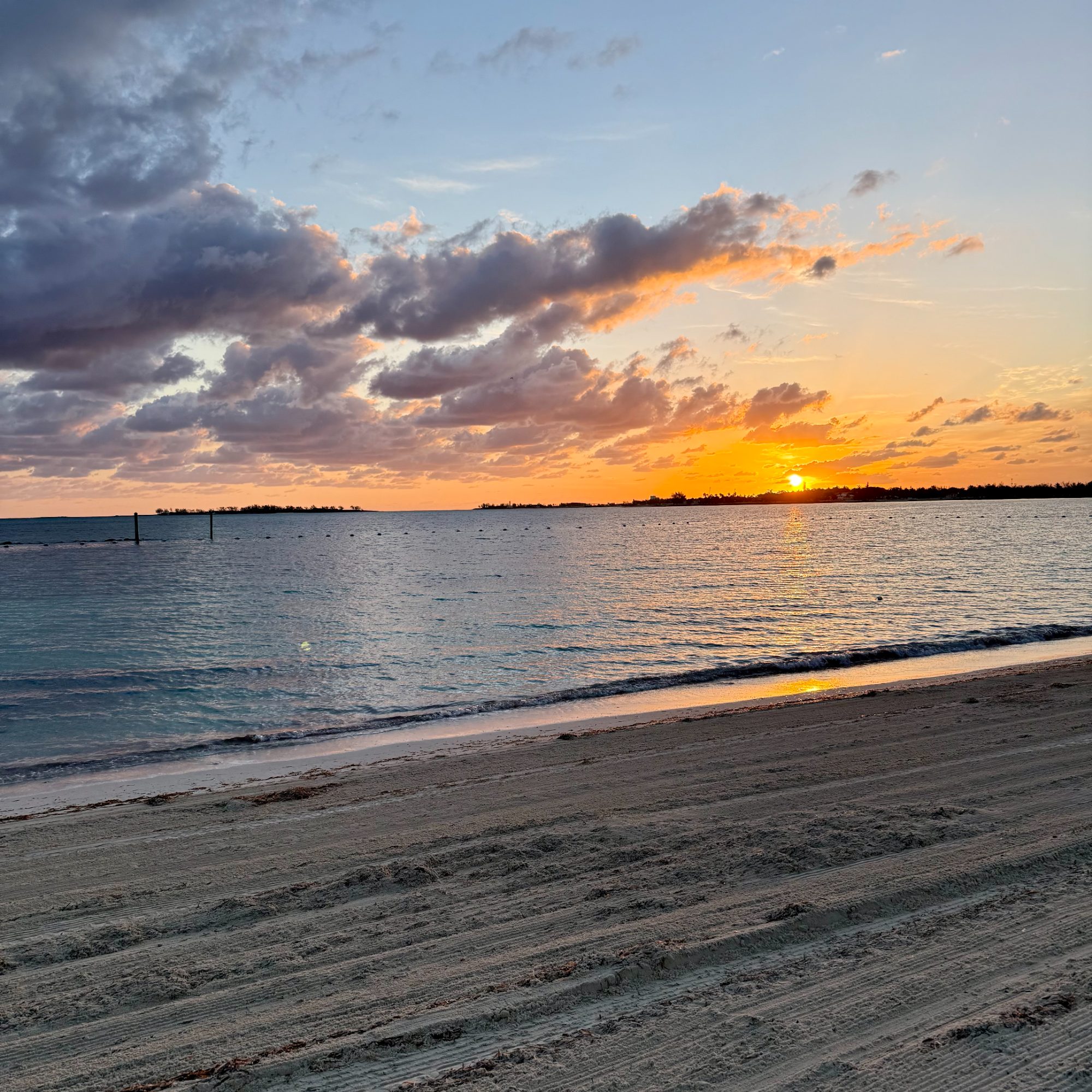 Golden sunset over a calm Bahamian beach