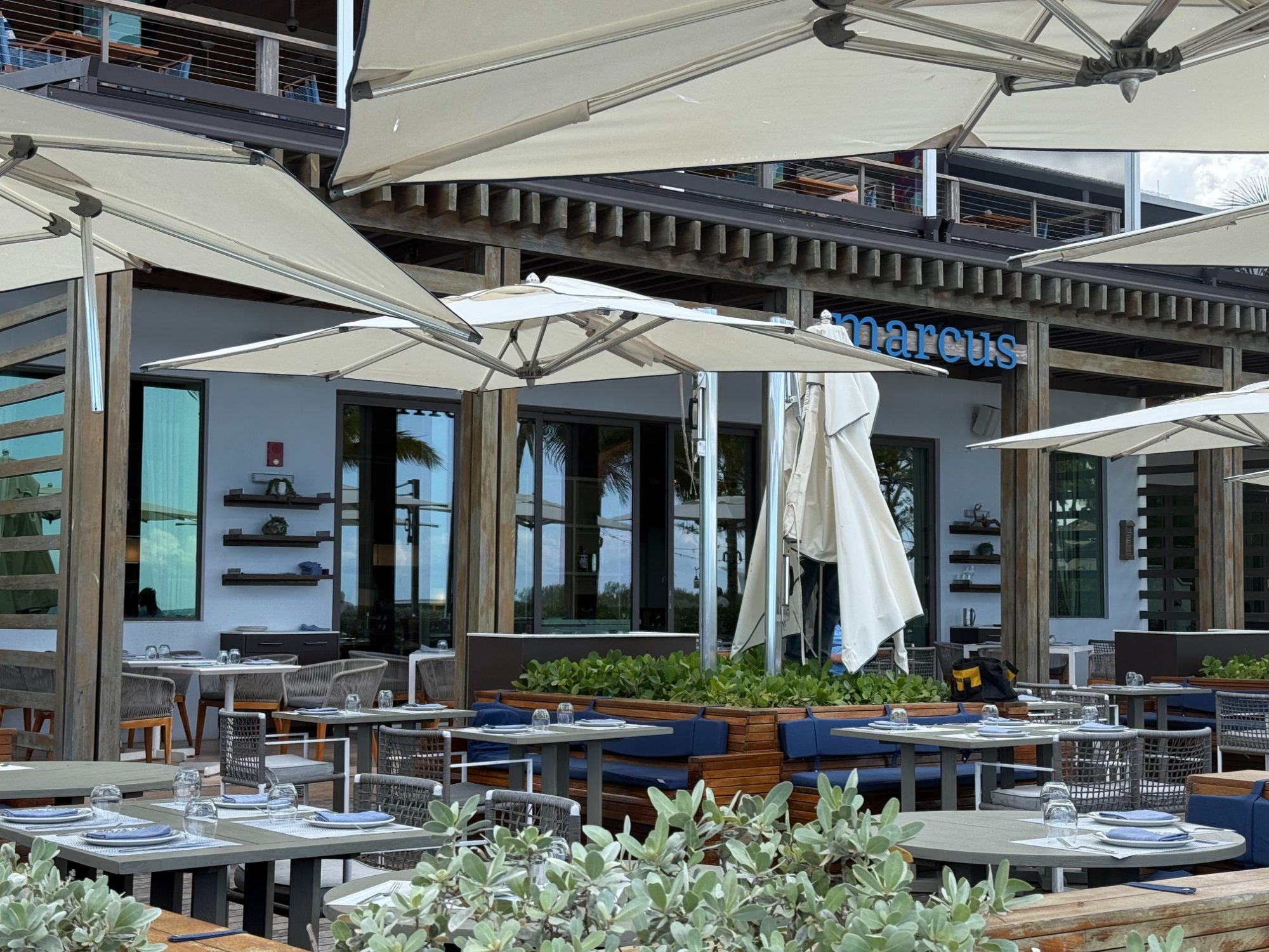 Beach club dining terrace with white umbrellas