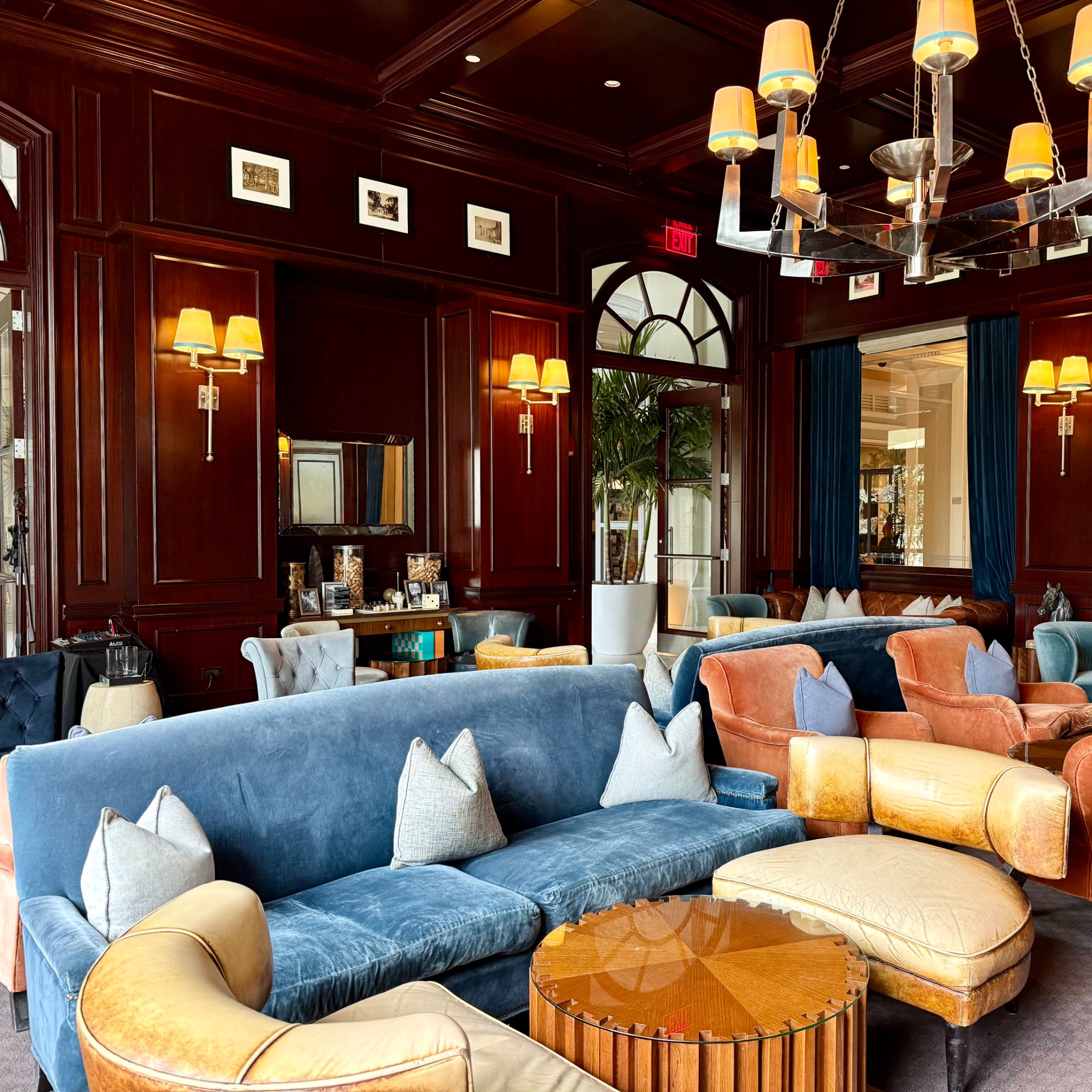 A sitting room with blue upholstery and warm lamplight